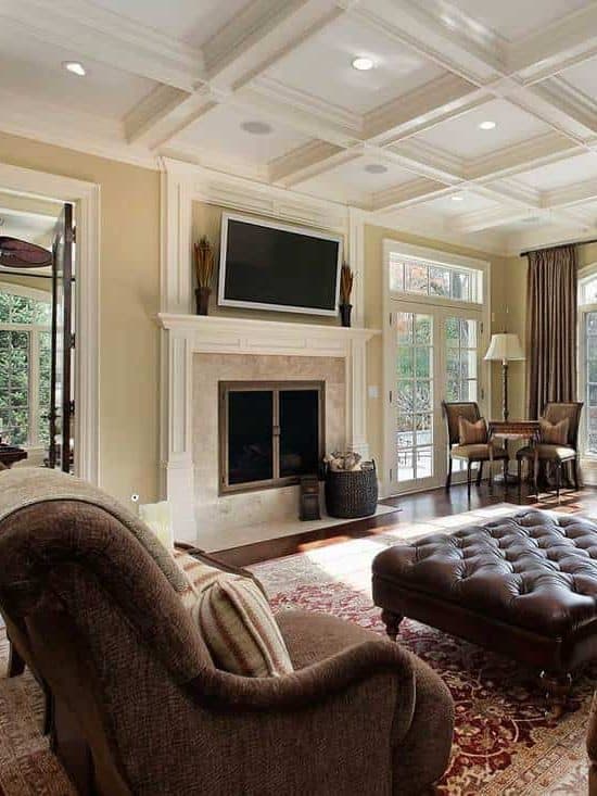 Large classic family room with fireplace, TV, cozy sofa and wall of windows