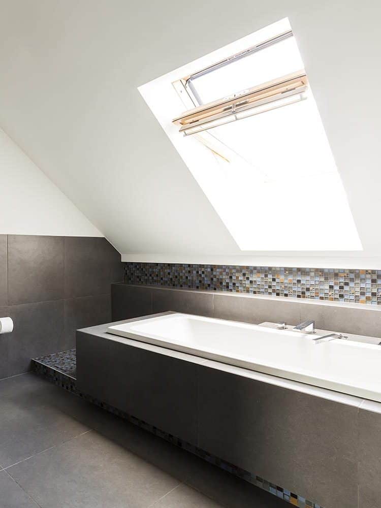 Stylish bathroom with transparent showerstall in the attic